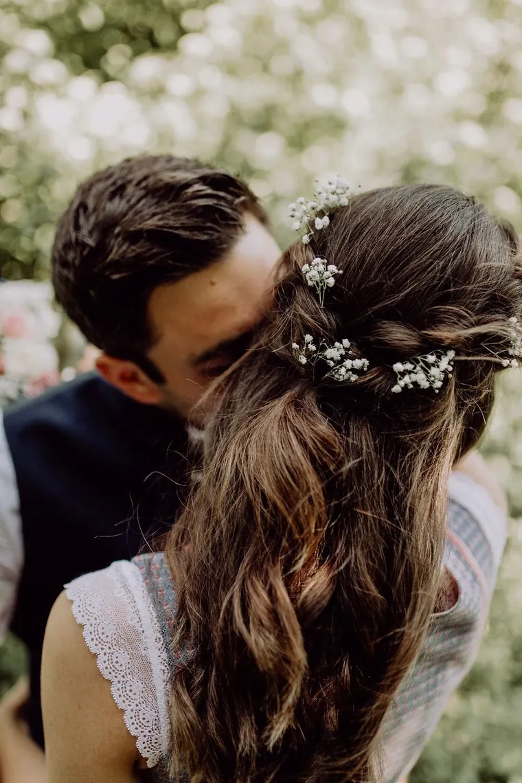 Halboffene Brautfrisur mit langen Locken und Blütenschmuck