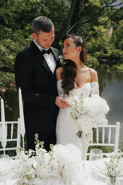 Brautpaar bei einer Hochzeit im Grünen mit weißen Blumen